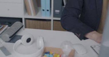 Ofiste bilgisayarla çalışan yorgun Asyalı adamın baş ağrısı çeken şakaklara masaj yapan portresi. İş ve stres kavramı.