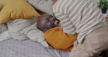 Yavaş hareket eden Afro-Amerikan çocuk babasıyla gülerek evde babasıyla oynuyor. Çocukluk ve babalık kavramı.