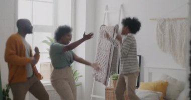 Yatak odasında dans eden kadın ve küçük çocuk yatakta zıplıyor ve evde birlikte eğleniyorlar. Aile hayatı ve eğlence anlayışı.