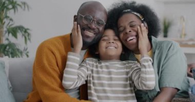 Afro-Amerikan mutlu aile babasının yavaş çekimde çekilmiş bir portresi. Evde kameraya bakıp eğlenen bir anne oğlu. İnsanlar ve mutluluk kavramı.