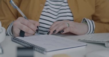 Not defterine iş fikirleri yazan kadınların yakın plan fotoğrafları ve ofiste bilgisayarla çalışmak. İş ve iş adamı kavramı.