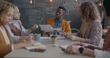 Çeşitli iş adamları evrak okuyarak iş toplantılarında fikir alışverişinde bulunuyorlar. İşbirliği ve yönetim kurulu konsepti.