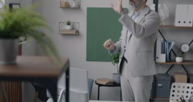 İş adamı, sanal gerçeklik gözlüğü kullanarak ofiste el ele tutuşup tatilin tadını çıkarıyor. Modern teknoloji ve işyeri kavramı.