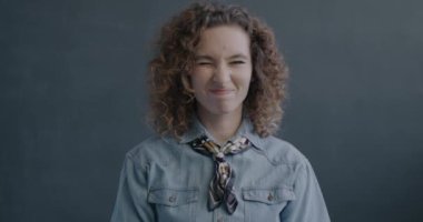 Hayal kırıklığına uğramış genç bir bayanın portresi siyah stüdyo arka planında hoşnutsuzluğunu ifade eden baş sallayarak el hareketi yapıyor. İnsanlar ve duygu kavramı.