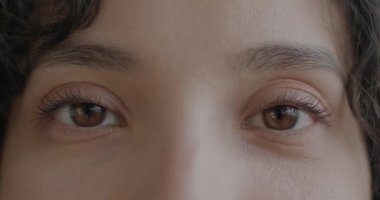 Orta Doğulu kadın gözlerinin yakın plan portresi duygusuzca yanıp sönen kameraya bakıyor. Yüz ifadesi ve insanların konsepti.