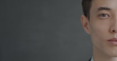 Siyah arka planda kameraya bakan genç bir adamın yavaş çekim portresi. İnsanlar ve ifade kavramı.