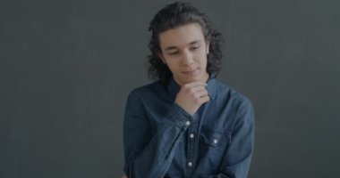 Parmak kaldırmayı düşünen İspanyol adamın portresi gri arka planda fikir sahibi. Yaratıcı çözüm ve eureka anı konsepti.