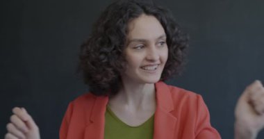 Siyah arka planda dans eden neşeli genç bayan portresi. Eğlence ve parti zamanı konsepti.