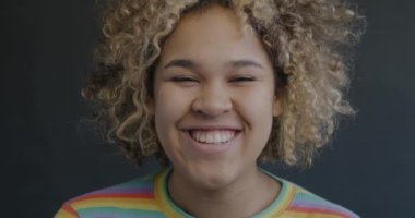 Siyah arka planda gülen mutlu Afro-Amerikan kadın portresi. Olumlu duygu ve eğlence kavramı.