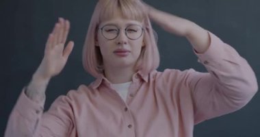 Siyah arka plandaki kameraya bakarak dans eden çekici genç bir kadının portresi. Parti ve eğlence konsepti.