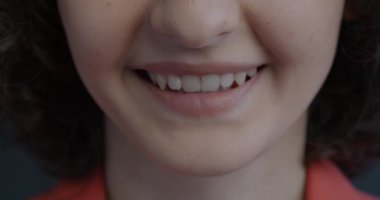 Siyah arka planda dişleri gösteren, gülümseyen bir kadın portresi. Pozitif duygu ve mutlu insanlar konsepti.