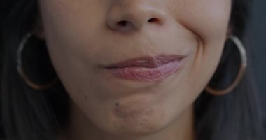 Gergin genç bir kadın dudaklarını büzüştürürken, dişinin dudaklarının buruşmasını yakından çek. Olumsuz duygu ve yüz ifade etme kavramı.