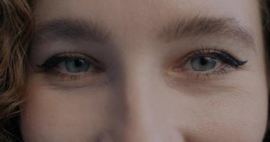 Neşeli kadın gözlerinin yakın plan portresi mutlu bir ifadeyle kameraya bakıyor. Bireysellik ve insan vücudu ayrımı kavramı.