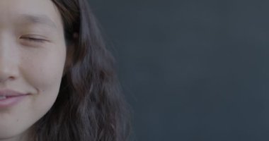 Siyah arka plandaki kameraya gülümseyen mutlu Asyalı kadın portresi. Pozitif duygu ve insanların kavramı.