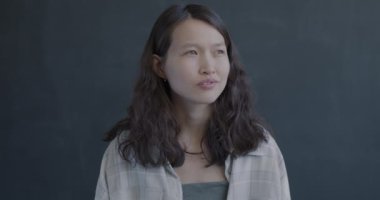 Düşünceli Asyalı kadın portresi parmak kaldırmayı düşünürken siyah arka planda harika bir fikri vardı. Yaratıcı düşünce ve insanların kavramı.