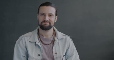 Kafasını sallayan adamın ağır çekim portresi. Yani arka plandaki kameraya bakarak kötü teklifi reddetmek yok. İnsanlar ve yüz ifadesi kavramı.