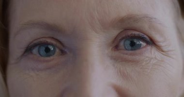 Bayan kendini kaygısız hissederken kameraya bakan yaşlı kadınların yakın plan portresi. Olgun insan ve olumlu duygu kavramı.