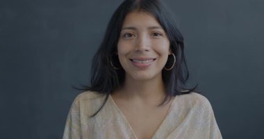 Siyah arka planda gülümseyen mutlu İspanyol kadın portresi. Mutlu insanlar ve olumlu duygu kavramı.