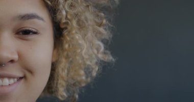 Siyah arka planda gülümseyen neşeli Afro-Amerikan kız portresi. Duygu ve ifade kavramı.