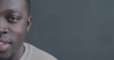 Siyah arka planda gülümseyen Afrikalı Amerikalı bir adamın portresi. İnsanlar ve iyi ruh hali kavramı.