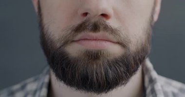 Gri arka planda mutluluğu ifade eden gülümseyen genç adamların yakın plan portresi. İnsan vücudu ve iyi ruh hali konsepti..