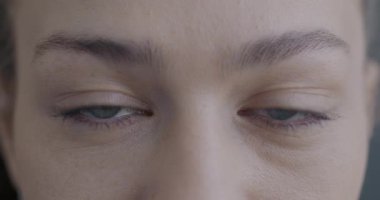 Yavaş çekimde, kameraya bakan güzel kadın gözlerinin görüntüsü. Gözünü kırpmadan. İnsan görüşü ve yüz ifadesi kavramı.