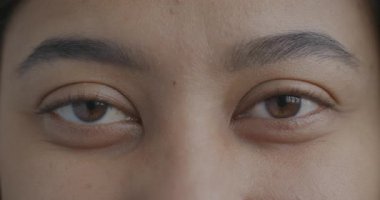 Çift ırklı kadınların kameraya duygusuz bakışlarının yavaş çekimde çekilmiş portresi. Yüz ifadesi ve insan vücudu parçası kavramı.