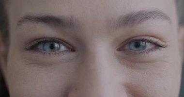 Yavaş çekimde, gülümseyen ve göz kırpan kameraya bakan mutlu genç kadınların portresi. Olumlu duygular ve neşeli insanlar konsepti.