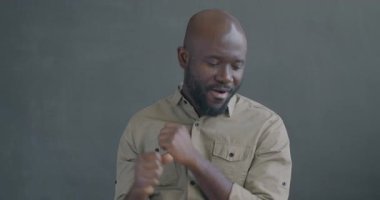 Siyah arka planda dans eden neşeli Afrikalı Amerikalı 'nın yavaş çekim portresi. Eğlence ve insan konsepti.