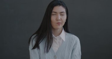 Asyalı yaratıcı genç kadının yavaş hareket eden portresi siyah arka planda fikir sahibi olarak parmak kaldırıyor. İnsanlar ve el hareketi konsepti.