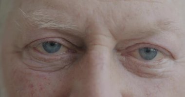 Kameraya neşeyle gülümseyen neşeli yaşlı adamların yavaş çekim portresi. Pozitif duygu ve yaşlılık kavramı.