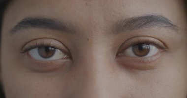 Yavaş çekimde, genç kadınların ifadesiz bir şekilde kameraya bakışlarının portresi. İnsan vücudu ve vizyon kavramı.