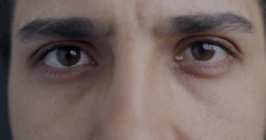 Ortadoğulu erkeklerin gergin bir ifadeyle kameraya bakışlarının yakın plan portresi. İnsanlar ve vücut parçaları kavramı.