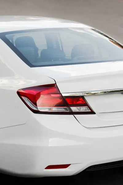 White modern car close-up details. Back side view with headlight and bumper details. Beautiful curved shapes with modern stylish design