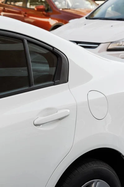 现代白色汽车的细节 门把手 油箱盖 关闭汽油盖 后面有模糊的汽车 汽车商业广告概念背景 图库图片