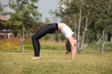 Sabahları dışarıda esneme egzersizleri yapan bir kadın. Güzel mutlu spor fitness modeli yaz günü dışarıda..