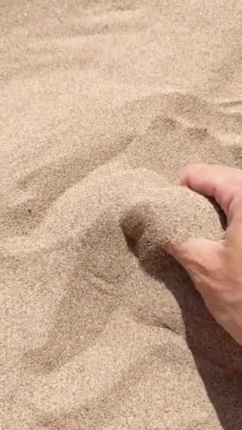 알아볼 수없는 여자가 모래를 손가락 사이로 돌립니다 해변을 여행하는 여행자는 — 비디오