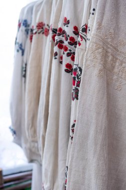 Vyshyvanka - Ukrayna ulusal birliği. Kırmızı, siyah ve beyaz çapraz dikiş. Ukrayna ulusal kıyafetleri mağazadaki askılarda asılı. Bulanık ve seçici odaklanma