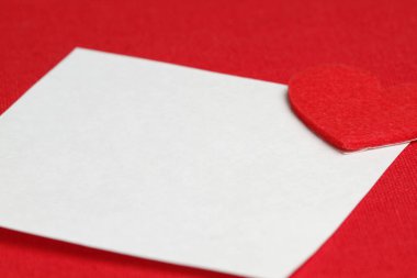 Kırmızı kalpli, kısa beyaz bir nota yakın plan. Sevgililer Günü geçmişi. Metin yazmak için kopyala. Aşk konsepti