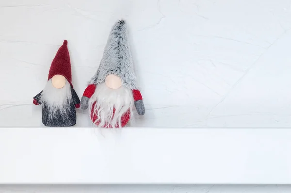 stock image Elves, Christmas decorations. Christmas Gonks sit on a white wooden shelf against the wall. Christmas and New Year concept, greeting card, copy space