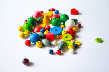 Farklı boyutlarda renkli ahşap tohum boncukları. Çevre dostu ahşap renkli bebek boncukları yapıyorum. Hobi, zanaat, yaratıcılık, ev kavramında boş zaman. El yapımı mücevherler.