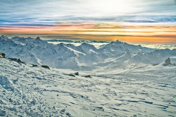 Greater Caucasus Mountain Range. Slopes are covered with snow above deep sunset sky. International Mountain Day - 11 December. International Mountaineering Day - 8 August