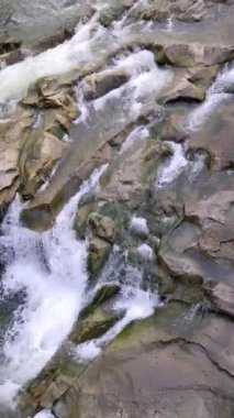 Mountain river with cold clear water. The river flows over the stones with little waterfall