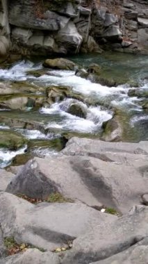 Mountain river with cold clear water. The river flows over the stones with little waterfall