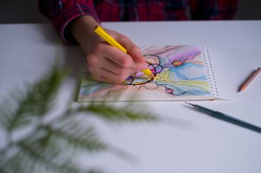 Renkli kalemlerle soyut nörografik çizimler. Nörografik resim çizen ellerin yakın çekimi. Renkli nörografi