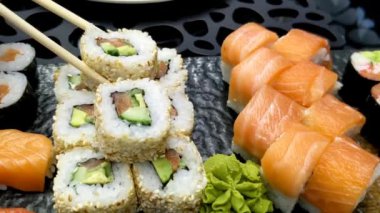 Suşi ruloları. Siyah tabakta değişik suşi çeşitleri.