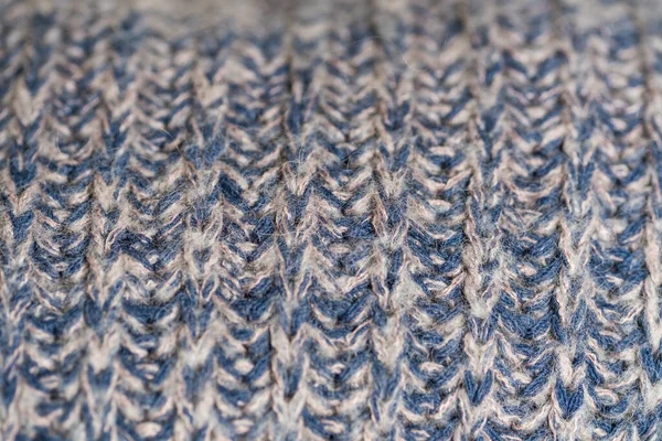 Hand knitted plaid. Geometric seamless knitted pattern. Knitted blue background, selective focus. Macro with shallow dof
