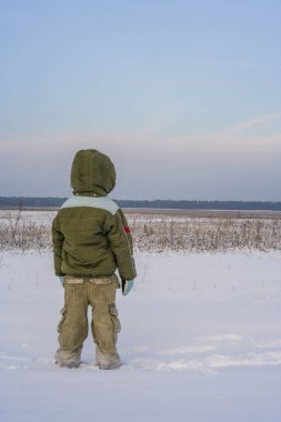 Photos from behind of boy. Little boy back view walking through the nature. Healthy active life