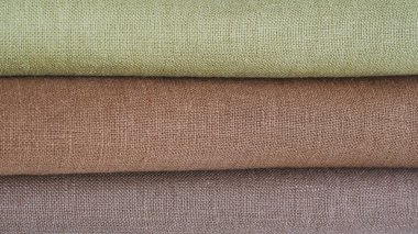 Green and brown linen background. Stripes of fabric
