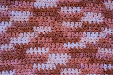 Hand-crocheted plaid. Geometric seamless knitted pattern. The texture is crocheted. Crochet. Knitted background